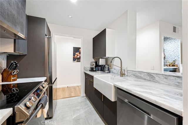 906 N Doheny Dr Unit 318, West Hollywood, CA 90069 - kitchen featuring a sink, stainless steel appliances, light marble finish flooring, light stone countertops, and baseboards