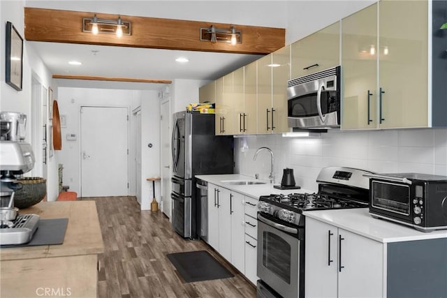 4215 Glencoe Ave Unit 103, Marina Del Rey, CA 90292 - kitchen with appliances with stainless steel finishes, a sink, wood finished floors, backsplash, and light countertops