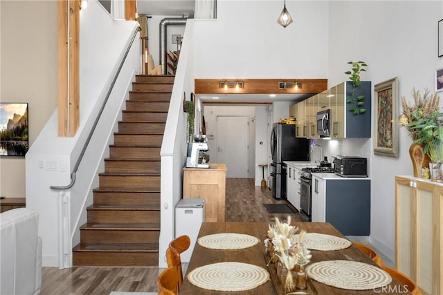 4215 Glencoe Ave Unit 103, Marina Del Rey, CA 90292 - dining space with a high ceiling, stairway, and wood finished floors