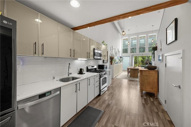 4215 Glencoe Ave Unit 103, Marina Del Rey, CA 90292 - kitchen with stainless steel appliances, a sink, beam ceiling, tasteful backsplash, and light countertops