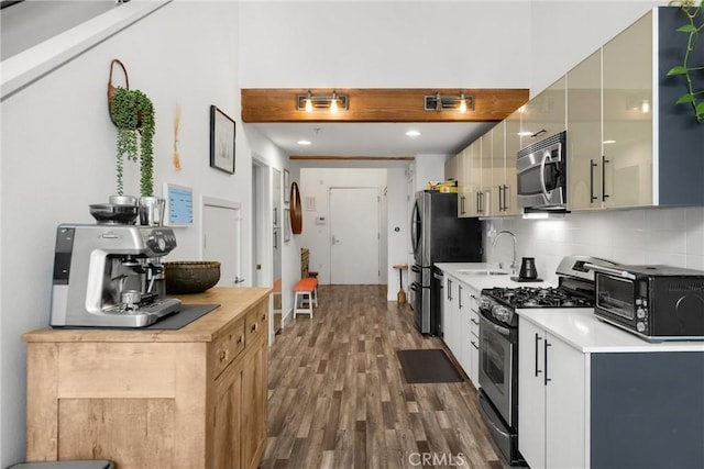 4215 Glencoe Ave Unit 103, Marina Del Rey, CA 90292 - kitchen with appliances with stainless steel finishes, a sink, wood finished floors, decorative backsplash, and light countertops