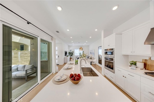 119 Zawn, Irvine, CA 92618 - kitchen featuring a sink, white cabinetry, open floor plan, light countertops, and light wood-type flooring
