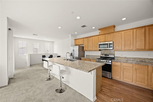 2333 S Via Esplanade Unit 25, Ontario, CA 91762 - kitchen featuring stainless steel appliances, a sink, a kitchen island with sink, recessed lighting, and light stone countertops