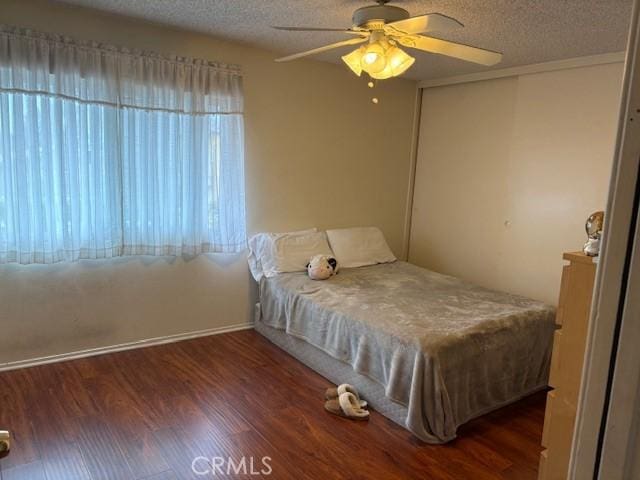 7100 Cerritos Ave Unit 112, Stanton, CA 90680 - bedroom featuring a textured ceiling, wood finished floors, a closet, ceiling fan, and baseboards