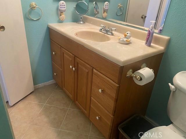 7100 Cerritos Ave Unit 112, Stanton, CA 90680 - bathroom with vanity, toilet, tile patterned floors, and a textured wall