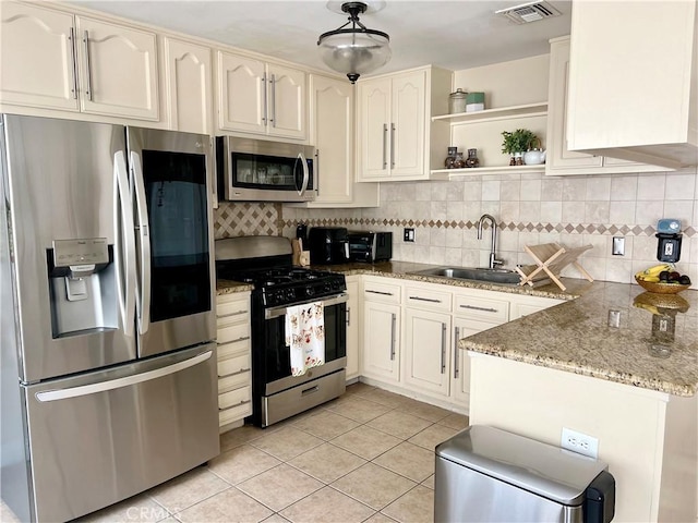 19950 Sherman Way Unit A, Winnetka, CA 91306 - kitchen featuring stainless steel appliances, a sink, light tile patterned floors, and tasteful backsplash