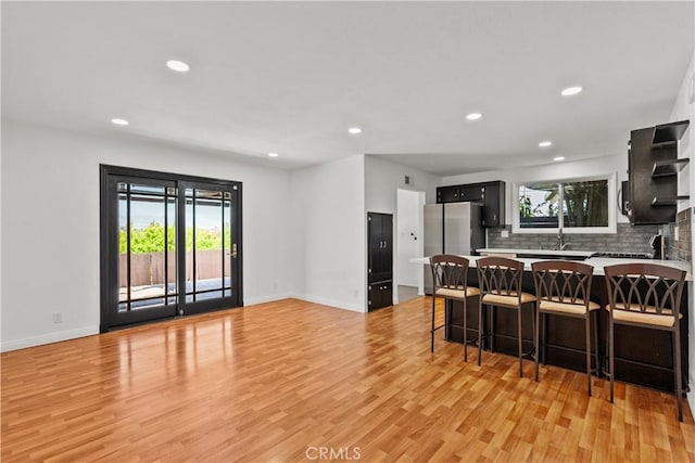 6172 Dalecrest Ave, Woodland Hills, CA 91367 - kitchen featuring light wood-style floors, backsplash, recessed lighting, a kitchen bar, and baseboards