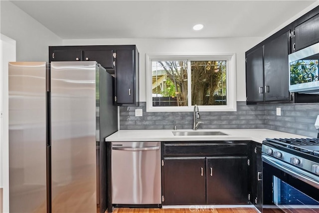6172 Dalecrest Ave, Woodland Hills, CA 91367 - kitchen with stainless steel appliances, a sink, dark cabinetry, light countertops, and backsplash