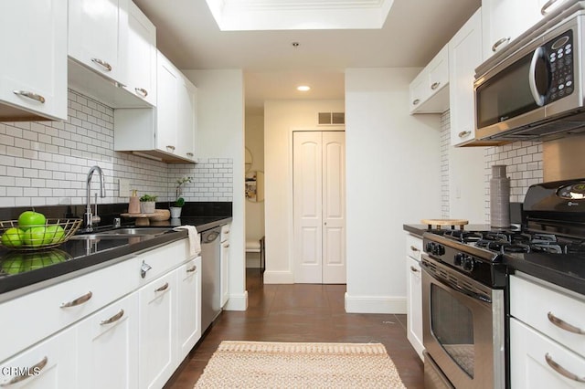 130 S Mentor Ave Unit 205, Pasadena, CA 91106 - kitchen with stainless steel appliances, dark countertops, a sink, recessed lighting, and white cabinets