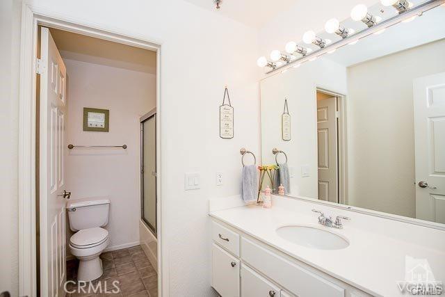 5805 Oak Bend Ln Unit 407, Oak Park, CA 91377 - full bath with vanity, toilet, tile patterned floors, and bath / shower combo with glass door