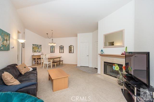 5805 Oak Bend Ln Unit 407, Oak Park, CA 91377 - carpeted living area with a chandelier, a fireplace with flush hearth, and lofted ceiling