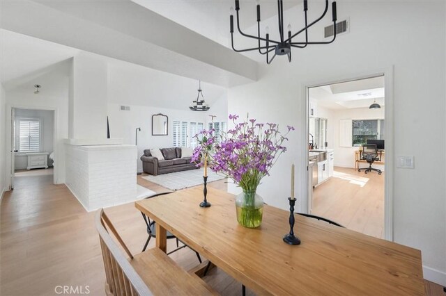 24148 Saint Moritz Dr, Valencia, CA 91355 - dining room featuring a chandelier, light wood-style flooring, an office area, a high ceiling, and baseboards