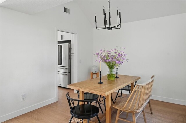 24148 Saint Moritz Dr, Valencia, CA 91355 - dining space featuring a chandelier, baseboards, light wood-style flooring, and vaulted ceiling