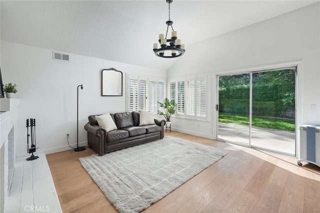 24148 Saint Moritz Dr, Valencia, CA 91355 - living room with a chandelier, light wood-style flooring, vaulted ceiling, baseboards, and a fireplace