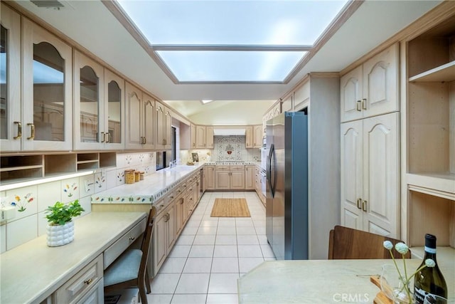 319 Calle Cuervo, San Clemente, CA 92672 - kitchen with freestanding refrigerator, light countertops, backsplash, light tile patterned floors, and glass insert cabinets