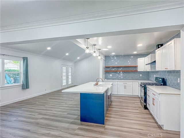 6275 Archibald Ave, Rancho Cucamonga, CA 91737 - kitchen with stainless steel gas range, light countertops, ornamental molding, white cabinets, and light wood-type flooring