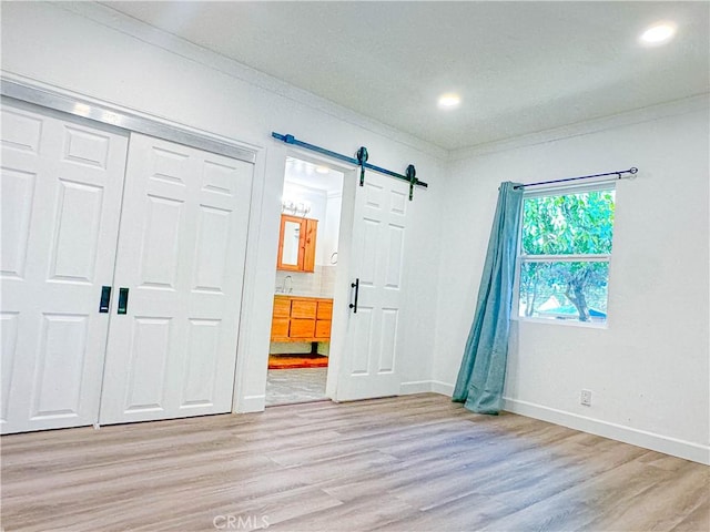 6275 Archibald Ave, Rancho Cucamonga, CA 91737 - unfurnished bedroom with light wood finished floors, crown molding, ensuite bathroom, a sink, and baseboards
