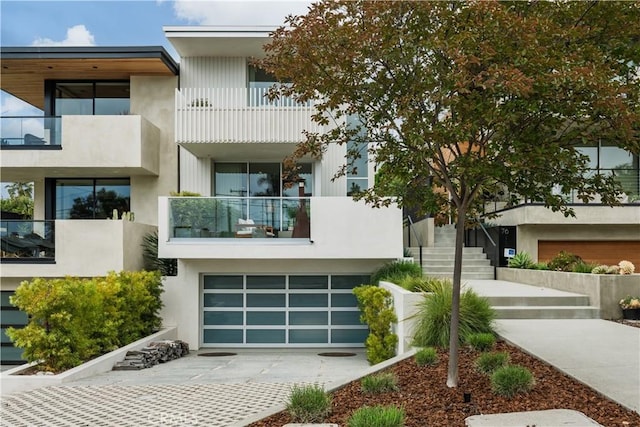 68 E F St, Encinitas, CA 92024 - contemporary house with concrete driveway, stairs, an attached garage, stucco siding, and a balcony