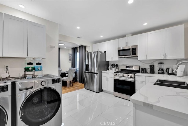 254 Piedmont Ave, Claremont, CA 91711 - kitchen with appliances with stainless steel finishes, a sink, separate washer and dryer, light stone counters, and white cabinetry