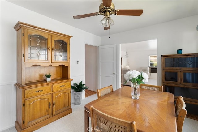 7933 Rhea Vista Dr, Whittier, CA 90602 - dining space featuring ceiling fan, light carpet, and a wainscoted wall