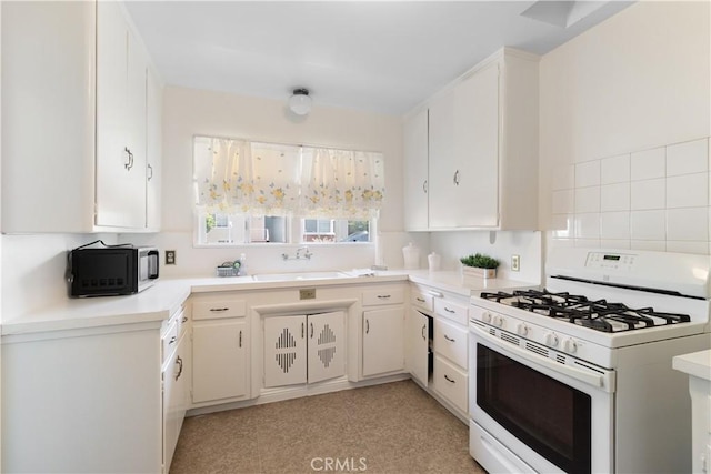 7933 Rhea Vista Dr, Whittier, CA 90602 - kitchen featuring white range with gas stovetop, a sink, black microwave, light countertops, and white cabinets