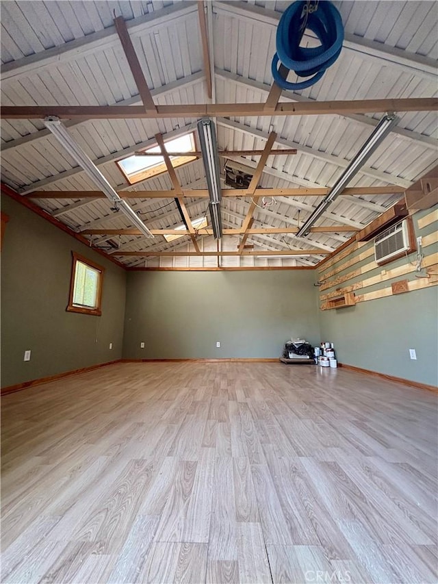 13617 Bassett St, Valley Glen, CA 91405 - empty room with wood finished floors, a skylight, lofted ceiling, and an AC wall unit