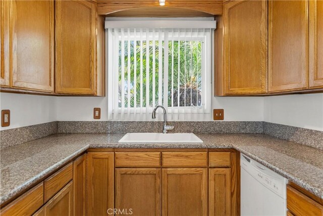 11676 Chesterton St, Norwalk, CA 90650 - kitchen featuring white dishwasher, a sink, and brown cabinetry