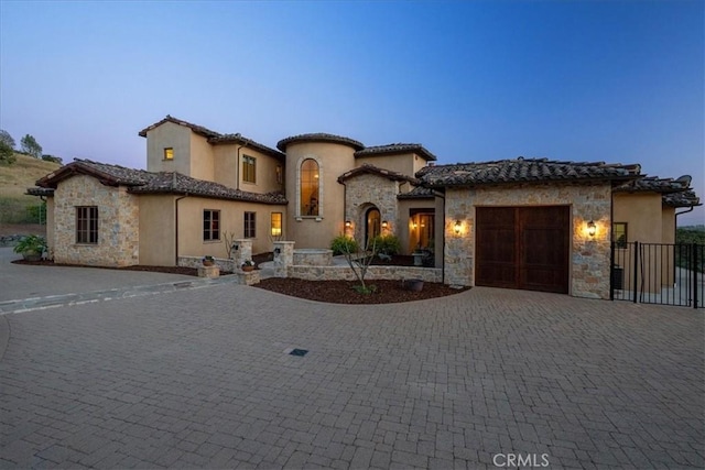 1470 Via Chaparral, Fallbrook, CA 92028 - mediterranean / spanish house featuring a garage, stone siding, decorative driveway, stucco siding, and a tiled roof