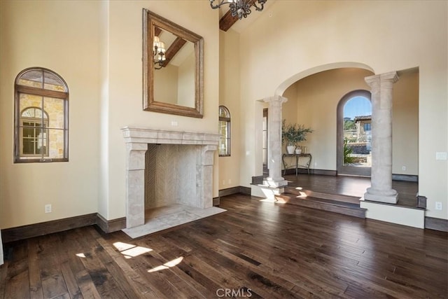 1470 Via Chaparral, Fallbrook, CA 92028 - unfurnished living room with high vaulted ceiling, arched walkways, decorative columns, wood-type flooring, and baseboards