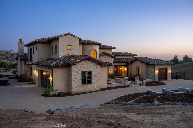 1470 Via Chaparral, Fallbrook, CA 92028 - mediterranean / spanish house featuring stone siding, stucco siding, a tiled roof, a garage, and driveway