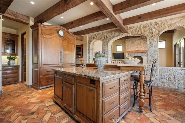 1470 Via Chaparral, Fallbrook, CA 92028 - kitchen featuring arched walkways, beamed ceiling, light stone counters, recessed lighting, and a center island with sink