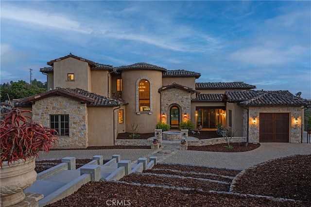 1470 Via Chaparral, Fallbrook, CA 92028 - mediterranean / spanish-style home with stone siding, stucco siding, a tile roof, and a garage