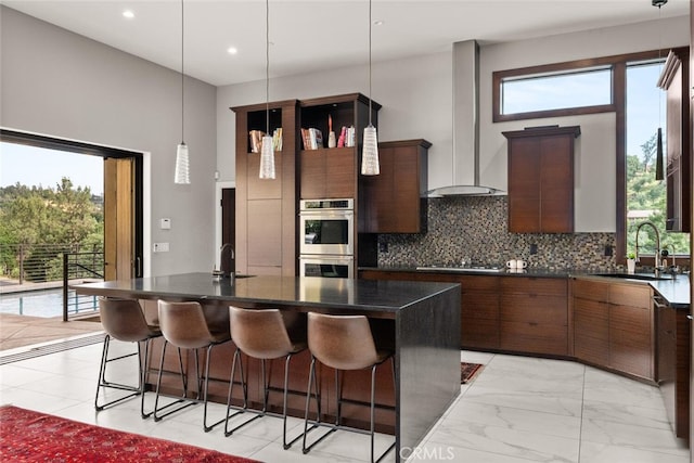 3386 Canyon Oaks Ter, Chico, CA 95928 - kitchen with a sink, appliances with stainless steel finishes, wall chimney range hood, a kitchen bar, and a center island with sink