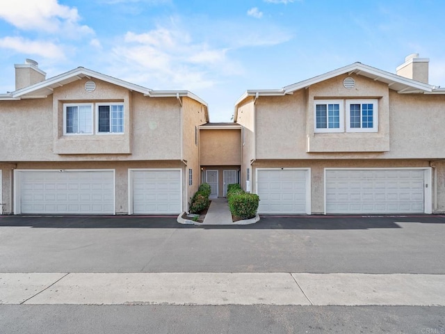 1465 E Lexington Ave Unit 11C, El Cajon, CA 92019 - view of property with a garage, a chimney, and stucco siding