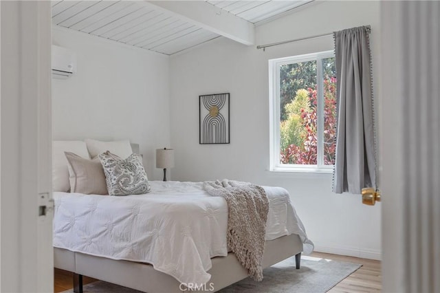 8521 Ranchito Ave, Panorama City, CA 91402 - bedroom with an AC wall unit, wood finished floors, wooden ceiling with exposed beams, and baseboards