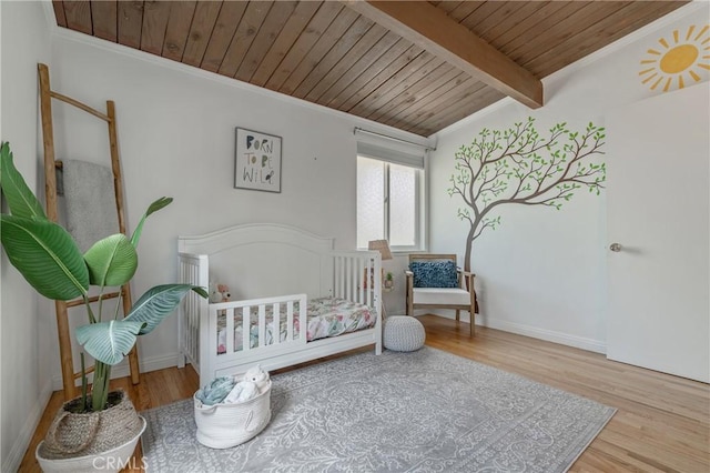8521 Ranchito Ave, Panorama City, CA 91402 - bedroom featuring wood ceiling with exposed beams, wood finished floors, ornamental molding, baseboards, and a nursery area