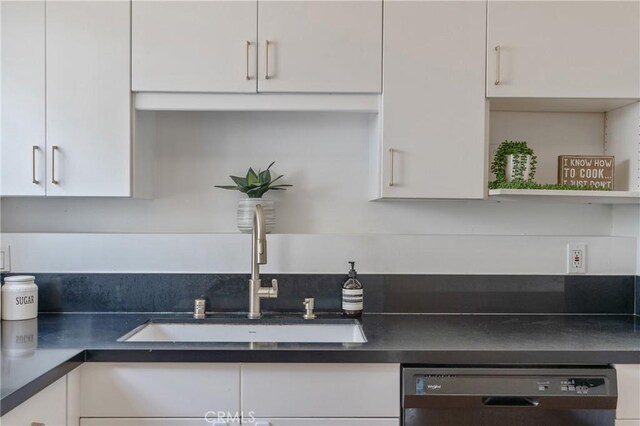 8521 Ranchito Ave, Panorama City, CA 91402 - kitchen featuring dishwashing machine, a sink, white cabinets, and dark countertops