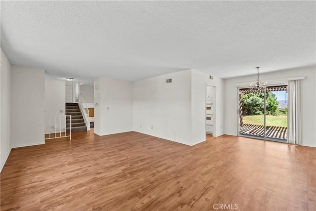 19627 Goldstream Way, Newhall, CA 91321 - unfurnished living room with light wood-style floors, a textured ceiling, stairs, a chandelier, and baseboards