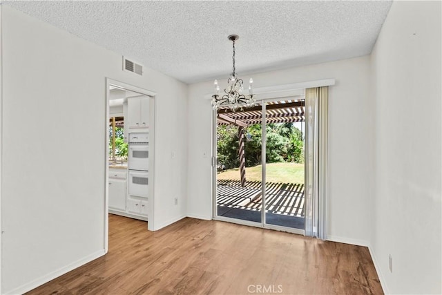 19627 Goldstream Way, Newhall, CA 91321 - unfurnished dining area with a chandelier, wood finished floors, a textured ceiling, and baseboards