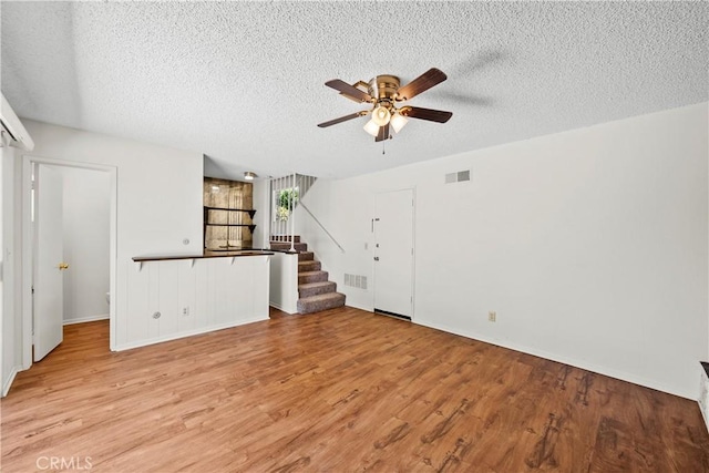 19627 Goldstream Way, Newhall, CA 91321 - unfurnished living room featuring a ceiling fan, a textured ceiling, stairs, light wood-type flooring, and baseboards