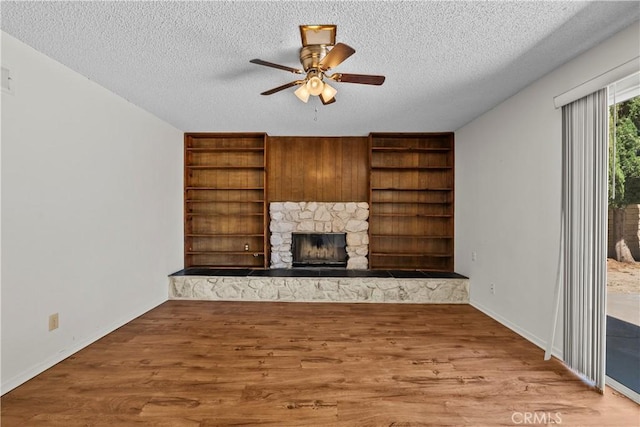 19627 Goldstream Way, Newhall, CA 91321 - unfurnished living room featuring a textured ceiling, a stone fireplace, a ceiling fan, wood finished floors, and baseboards