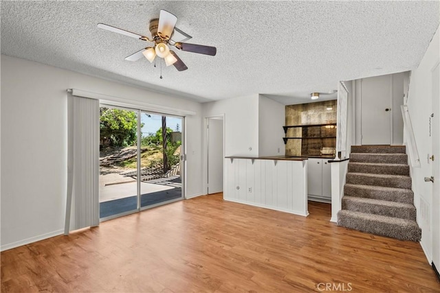 19627 Goldstream Way, Newhall, CA 91321 - unfurnished living room with a textured ceiling, light wood-style floors, ceiling fan, stairway, and baseboards