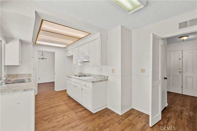 19627 Goldstream Way, Newhall, CA 91321 - kitchen featuring a sink, light wood-style floors, white cabinetry, light countertops, and a chandelier