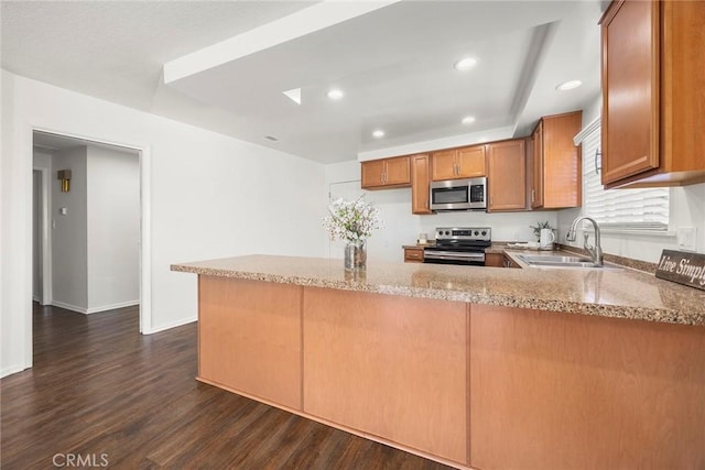 1418 E Wilshire Ave, Fullerton, CA 92831 - kitchen featuring stainless steel appliances, a sink, brown cabinetry, dark wood finished floors, and a peninsula