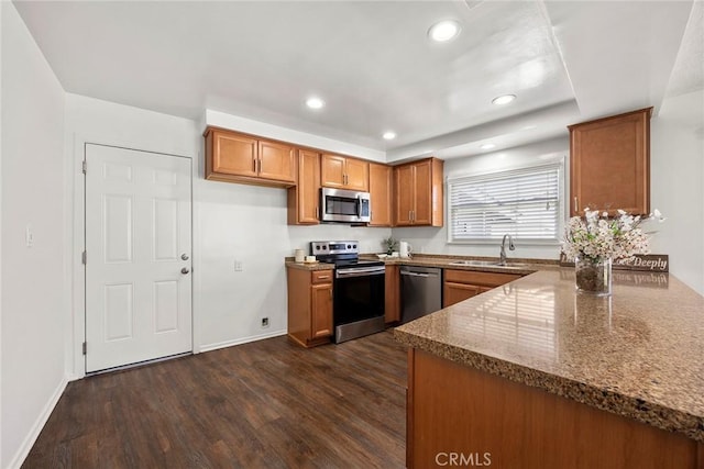 1418 E Wilshire Ave, Fullerton, CA 92831 - kitchen featuring stainless steel appliances, brown cabinets, a sink, dark wood-type flooring, and dark stone counters