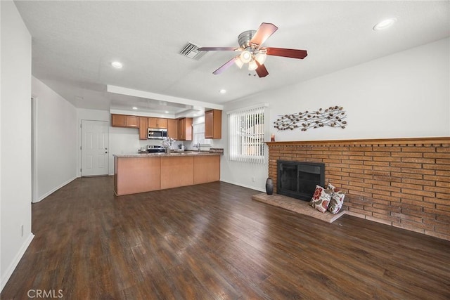 1418 E Wilshire Ave, Fullerton, CA 92831 - unfurnished living room with dark wood-style flooring, a ceiling fan, a brick fireplace, baseboards, and recessed lighting