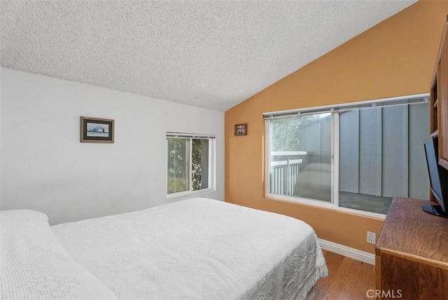 17152 Pacific Coast Unit 19, Huntington Beach, CA 92649 - bedroom featuring wood finished floors, vaulted ceiling, a textured ceiling, and baseboards
