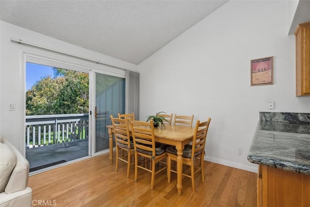 17152 Pacific Coast Unit 19, Huntington Beach, CA 92649 - dining room featuring light wood-type flooring, lofted ceiling, baseboards, and a textured ceiling