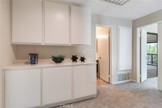 2209 E Badillo St, Covina, CA 91724 - kitchen with light carpet, light countertops, white cabinets, and baseboards