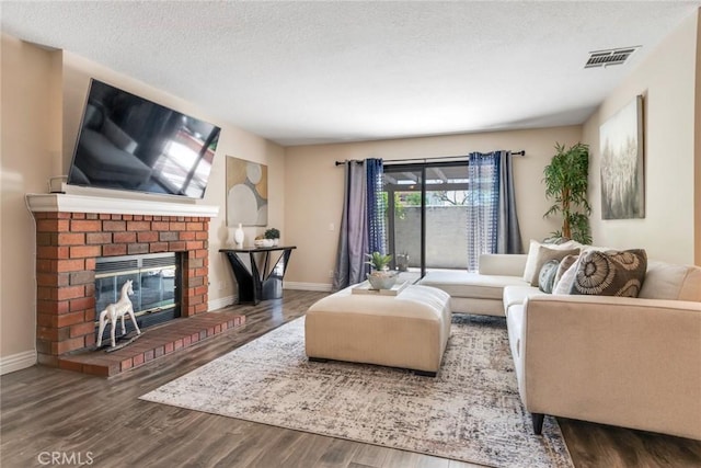 2209 E Badillo St, Covina, CA 91724 - living room with wood finished floors, a textured ceiling, baseboards, and a brick fireplace